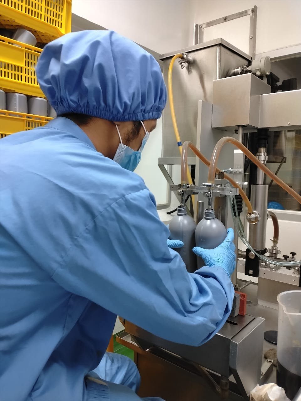 A production machine filling bottles on the line