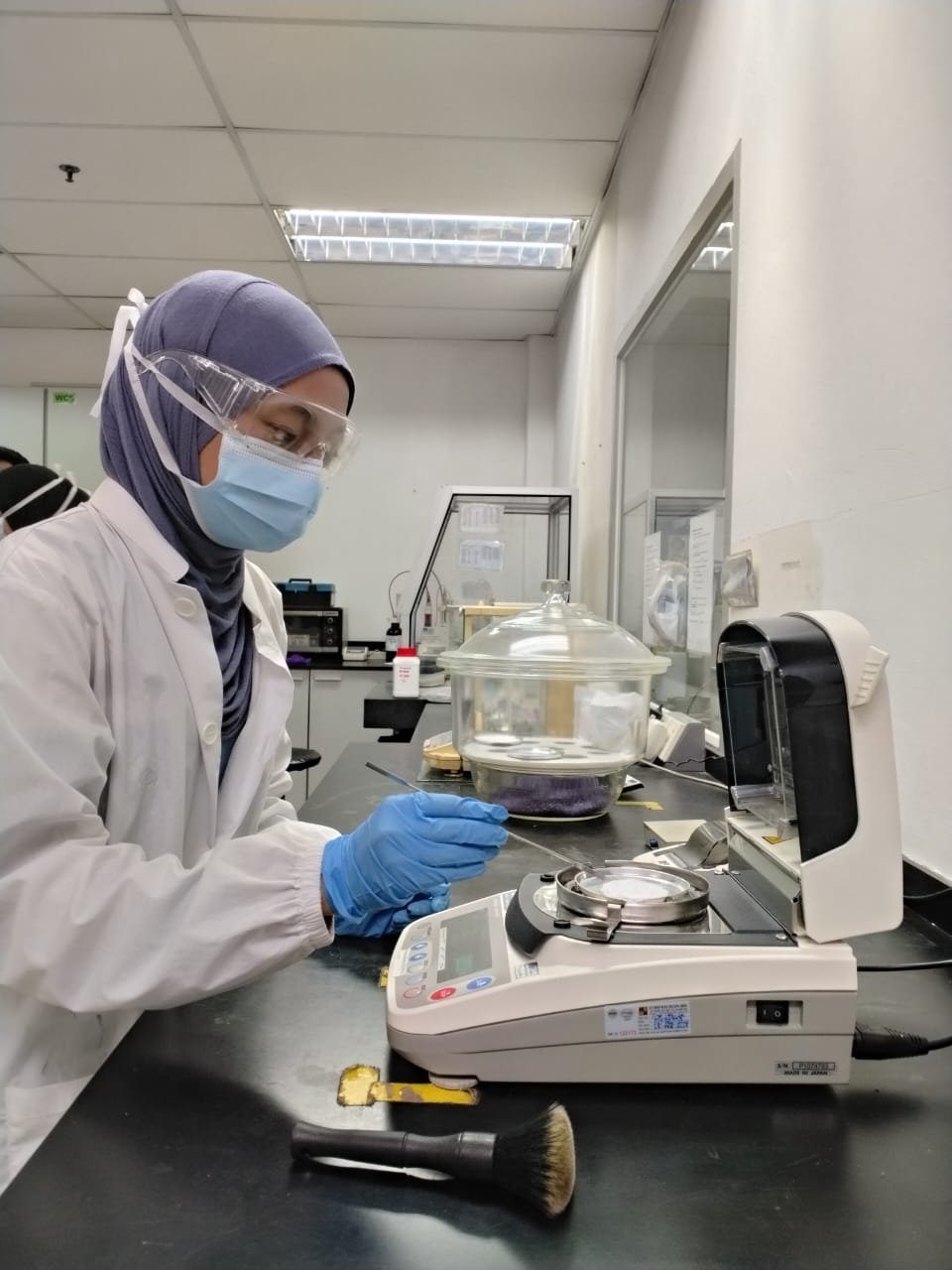 A Range Pharma analyst weighing a sample on a precision balance in the QC lab